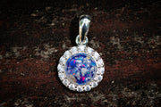 Silver pendant with a blue gemstone on a dark wooden background sapphire blue